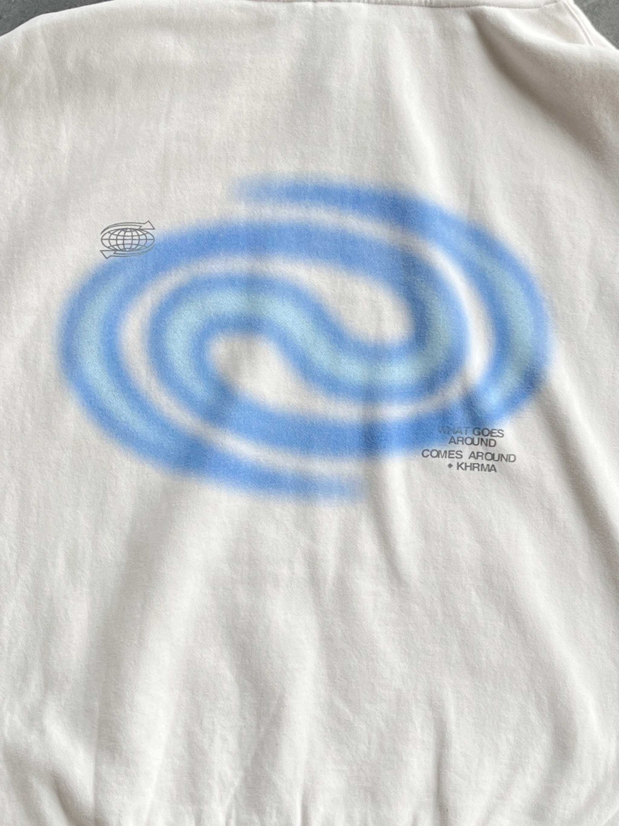 White t-shirt with blue spiral design and text